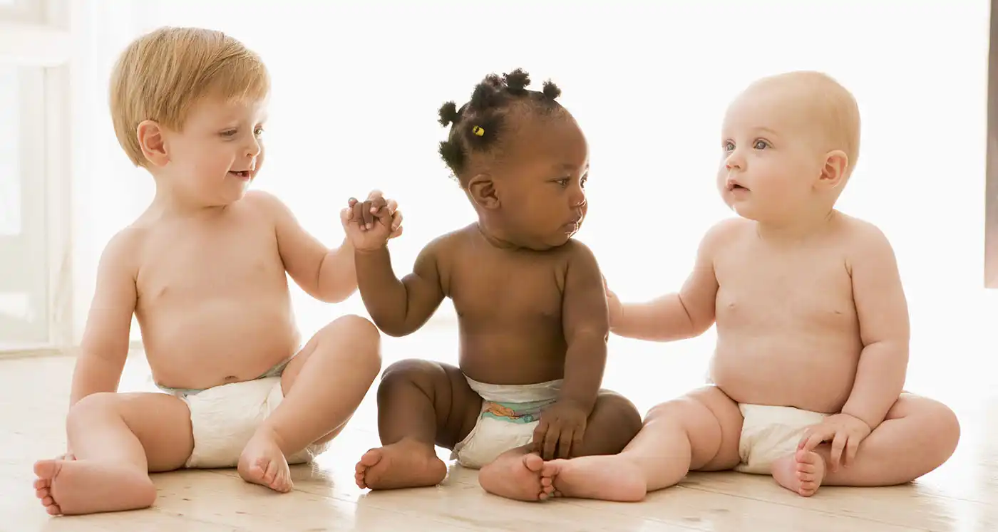 three babies sitting holding hands